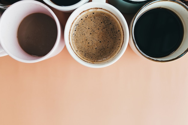 Plusieurs tasses à café sur fond beige. Photo de haute qualité