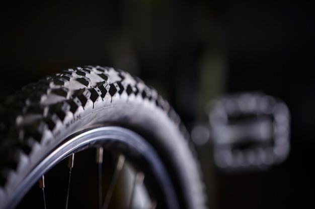 Photo pneu en caoutchouc noir avec des pointes pour une roue de vélo. accessoires de vélo