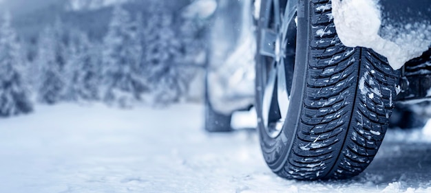 Pneu d'hiver Détail des pneus de voiture en hiver sur la route couverte de neige Bannière Panorama