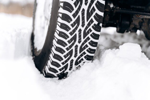 Pneus hiver à froid extrême. Gros plan des pneus de voiture en hiver sur la route couverte de neige. Notion de transport