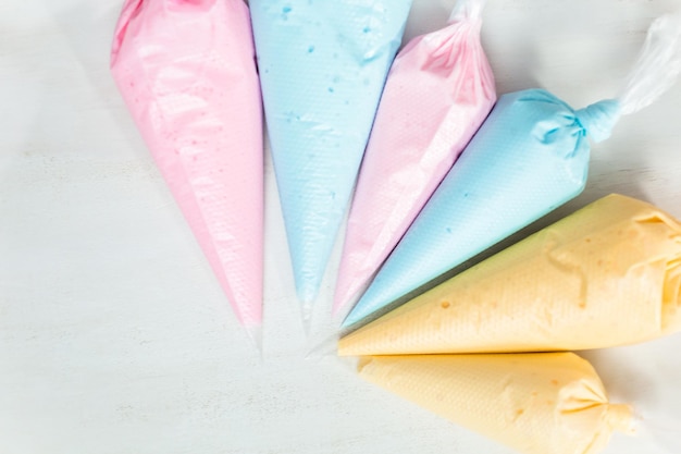 Poches à douille avec glaçage royal de couleur pastel pour décorer les biscuits au sucre de Pâques.