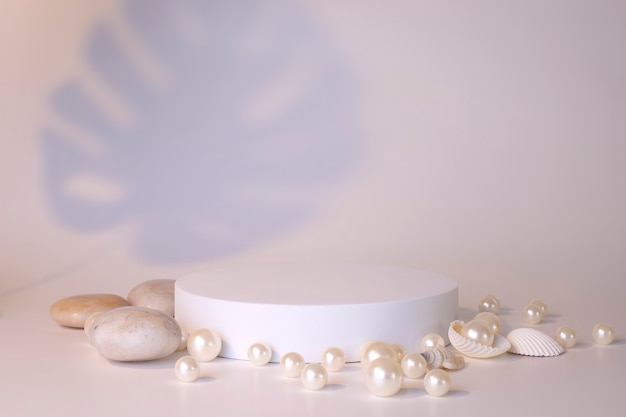 Photo podium blanc sur fond blanc avec perles et coquillages. podium pour le produit, présentation cosmétique. maquette créative. piédestal ou plateforme pour produits de beauté. conception minimaliste.