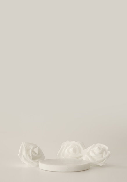 Podium en marbre blanc sur fond blanc avec des fleurs. Podium pour le produit, présentation cosmétique. Maquette créative. Piédestal ou plateforme pour produits de beauté.