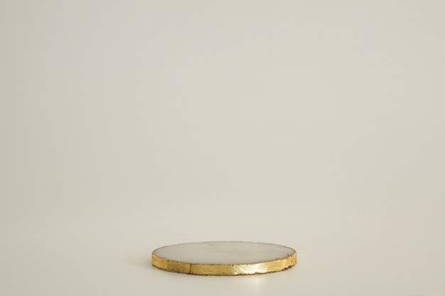 Podium en marbre avec de l'or sur fond blanc. Podium pour le produit, présentation cosmétique. Maquette créative. Piédestal ou plateforme pour produits de beauté. Design minimaliste
