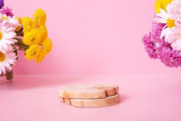 Podium ou piédestal en bois avec fleurs de chrysanthème sur fond rose Maquette pour vos produits cosmétiques