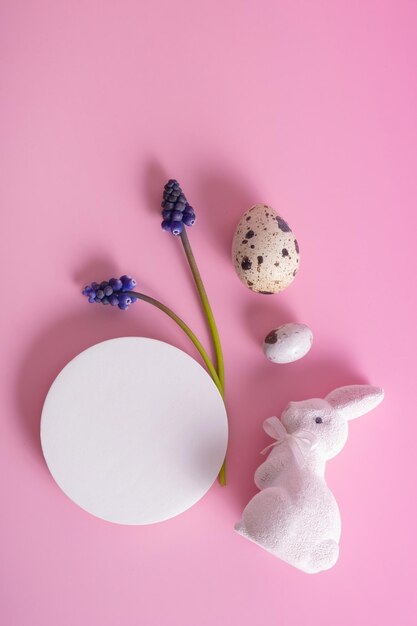 Podium ou plate-forme vide et lapin blanc avec des œufs symbole de Pâques sur fond rose