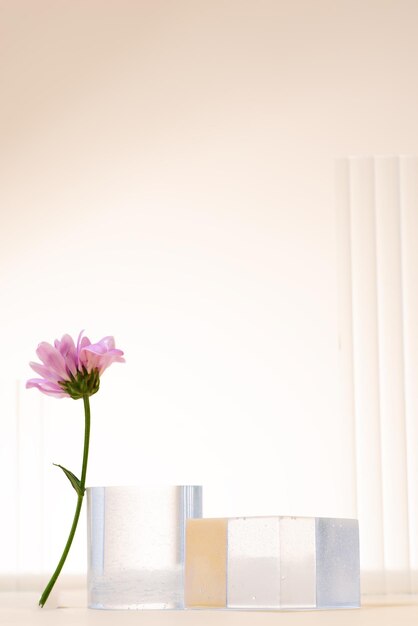 Podium en verre et scène minimale de fleurs sur un fond beige Stand pour montrer un produit cosmétique