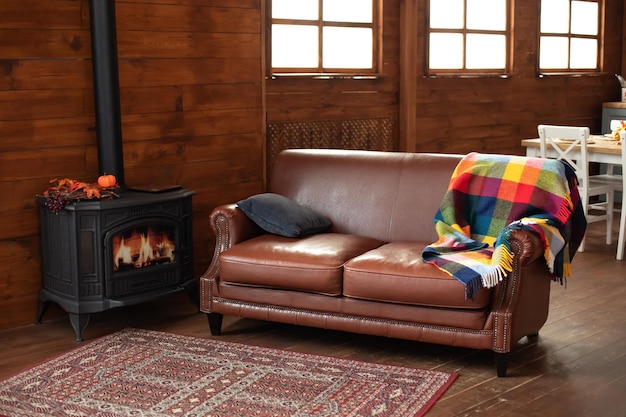 Poêle à bois en fonte moderne noir à la maison et canapé confortable à l'intérieur de la maison de campagne