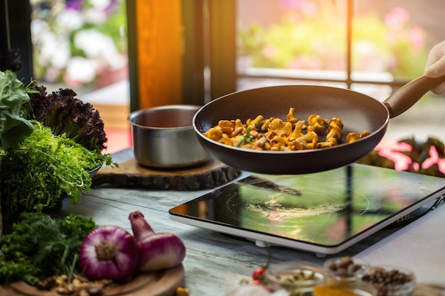 Poêle à frire aux champignons jaunes laitue de couleur verte très délicieuses girolles frites cuisiner des aliments ...