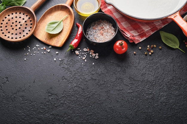 Photo poêle à frire blanc noir assiette vide feuilles de basilic et épices sur fond de pierre sombre résumé fond de nourriture vue de dessus de la table de cuisine rustique sombre avec cadre d'ustensiles de cuisine en bois maquette