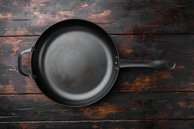 Poêle à frire en fonte avec espace de copie pour le texte ou la nourriture avec espace de copie pour le texte ou la nourriture, vue de dessus à plat, sur un vieux fond de table en bois foncé