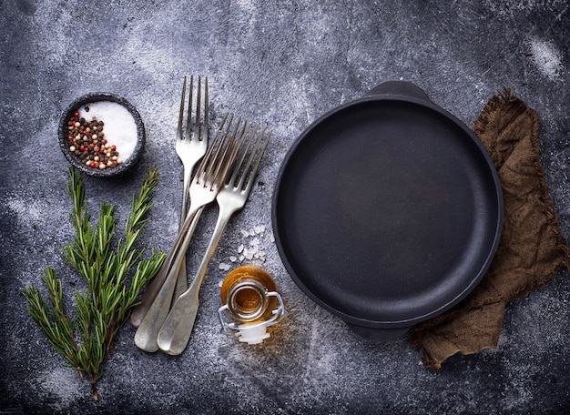 Poêle à frire en fonte avec herbes et épices