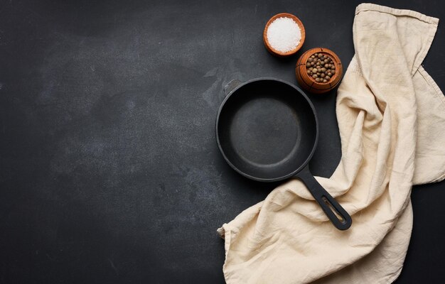 Poêle à frire en fonte ronde noire vide avec poignée sur la vue de dessus de table noire Espace de copie