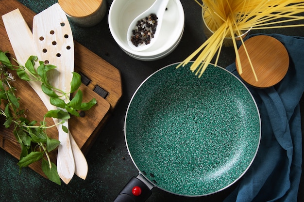 Poêle à frire vide avec revêtement en céramique sur une table de cuisine en pierre. Vue de dessus fond plat.