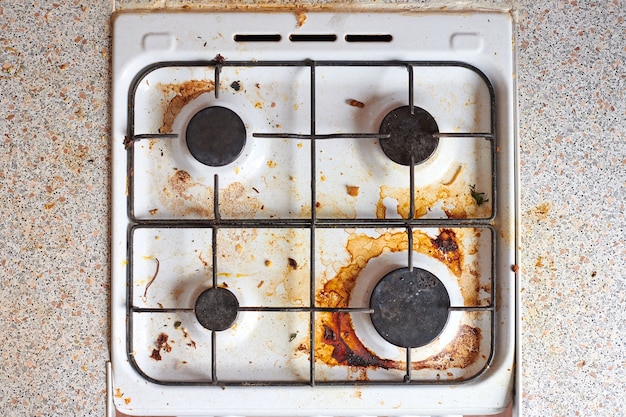 Poêle à graisse sale avec des restes de nourriture. Table de cuisson à gaz sale avec taches de graisse, vieilles taches de graisse, taches de friture et éclaboussures d'huile.