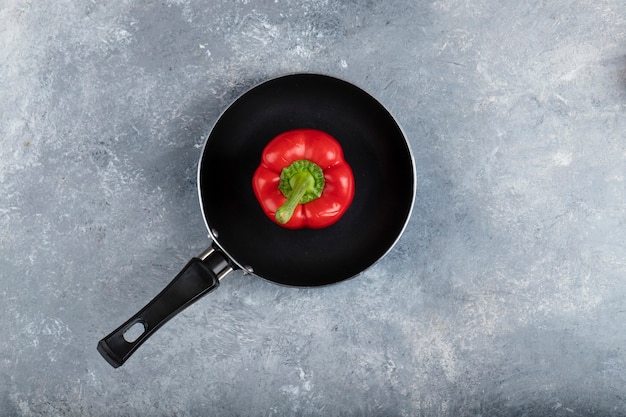 Poêle noire de poivron rouge sur la surface de la pierre