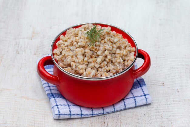 Poêle rouge avec bouillie de blé bouilli. Fermer