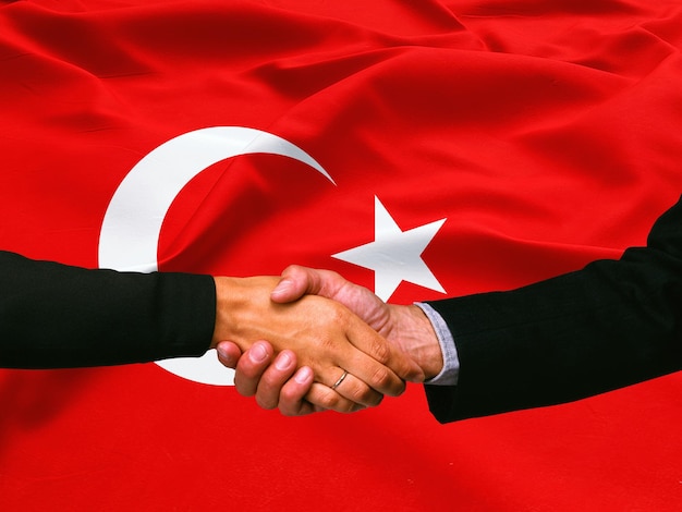 Poignée de main d'affaires sur le fond de drapeau de la Turquie