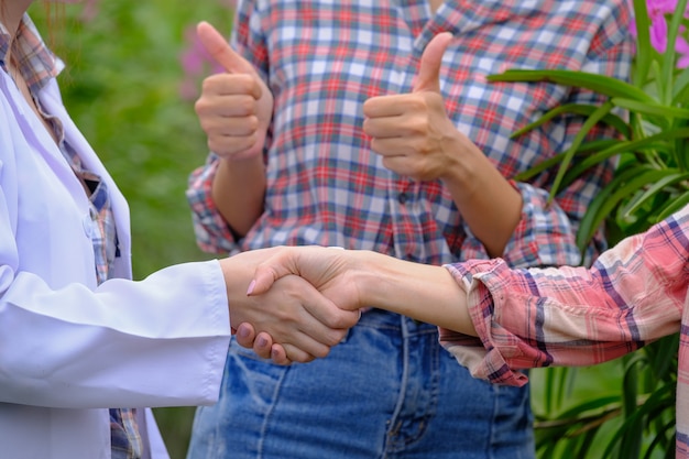 Poignée De Main Des Chercheurs Et Des Propriétaires De Jardin D'orchidées