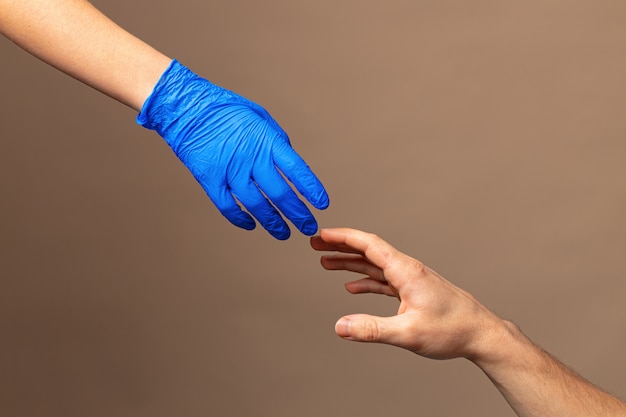 Poignée de main dans des gants bleus, concept d'aide.
