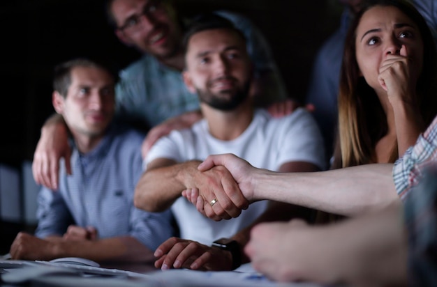 Poignée de main employés heureux à la table de bureau