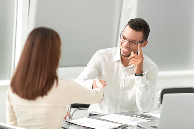 Poignée de main entre le Manager et le client dans un bureau lumineux