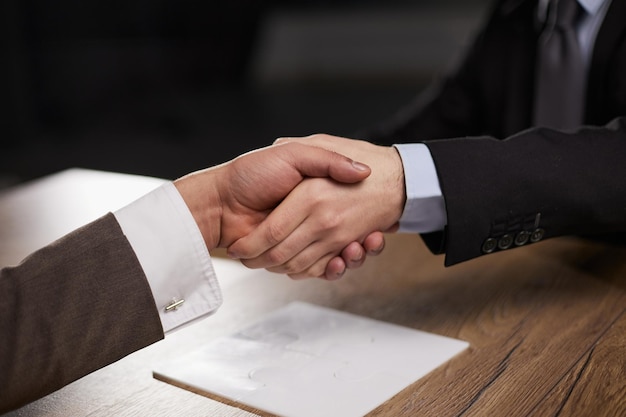 Poignée de main de gens d'affaires sur l'accord d'hommes d'affaires de table en bois et le concept de partenariat