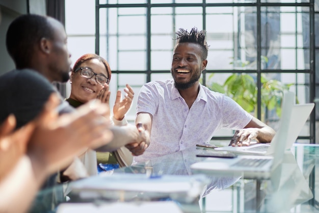 Poignée de main de gens d'affaires africains au bureau moderne