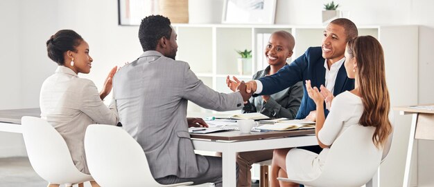 Poignée de main de gens d'affaires et applaudissements de réunion en collaboration pour une idée ou une stratégie d'entreprise au bureau Groupe d'employés se serrant la main dans un partenariat b2b ou un travail d'équipe sur le lieu de travail