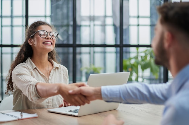 Poignée de main de gens d'affaires assis à la table du bureau