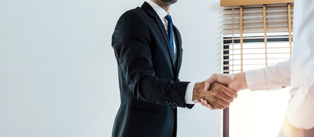 Photo poignée de main large bannière panoramique hommes d'affaires après la signature d'un contrat d'entreprise dans la salle de réunion au bureau de l'entreprise entretien d'embauche de partenariat négociation avec les investisseurs partenariat et concept de travail d'équipe