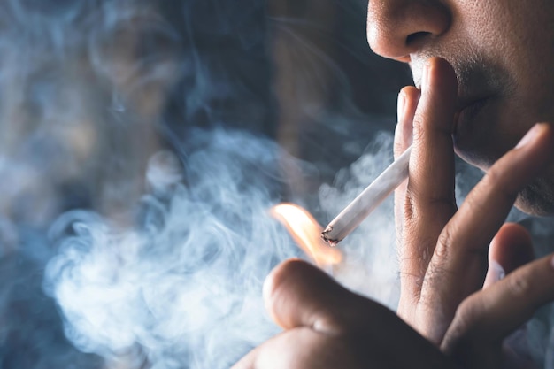 Photo la poignée masculine utilise des briquets pour fumer une cigarette