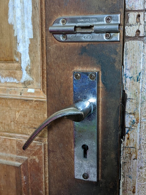 Poignée de porte argentée sur porte marron