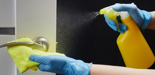 Poignée de porte sur la désinfection des portes blanches et sprays pour la prévention des infections virales pendant le COVID-19.