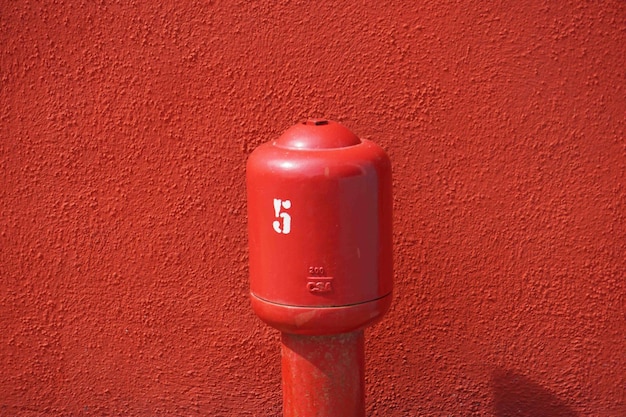 Photo poing métallique rouge contre le mur