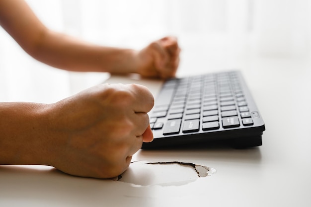 Poings féminins et table cassée avec un trou Concept de stress et de colère