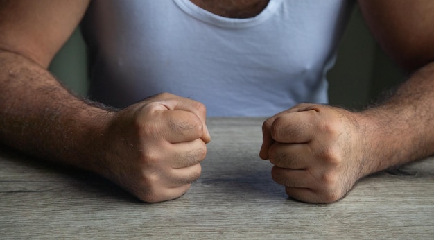 Photo les poings d'un homme en colère frappent sur la table.