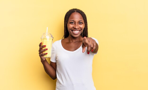 Pointant la caméra avec un sourire satisfait, confiant et amical, vous choisissant. concept de milk-shake