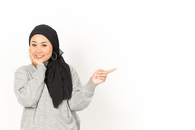 Pointant de côté de Beautiful Asian Woman Wearing Hijab isolé sur fond blanc