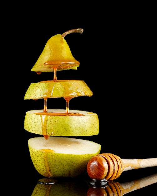 Poire au miel sur fond noir Délicieux dessert aux fruits Le miel coule sur la poire