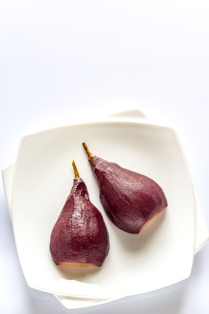 Poire pochée au merlot sur l'assiette