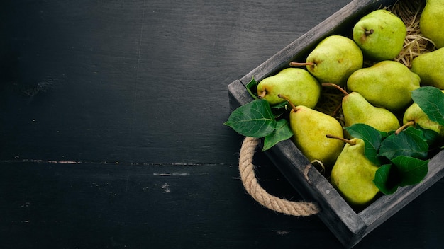 Poire verte fraîche Assortiment de poires dans une boîte en bois Sur le tableau noir Espace libre pour le texte Vue de dessus