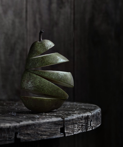 Poire verte hachée sur la table circulaire en bois et un mur de planche de bois