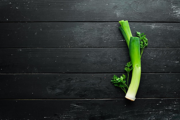Poireau vert cru sur fond noir Légumes pour une alimentation saine Vue de dessus Espace de copie gratuit
