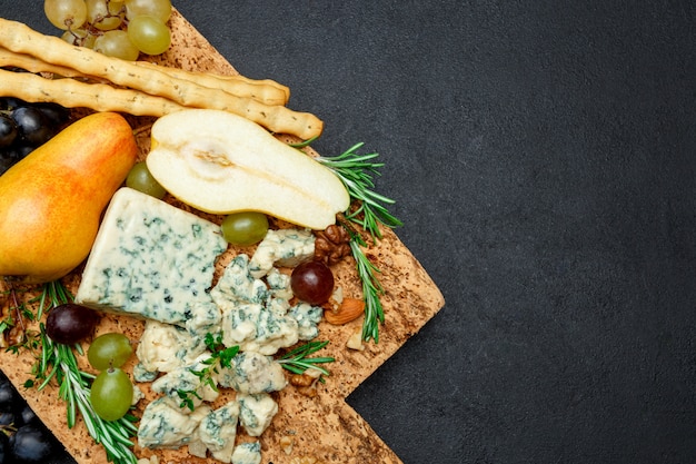 Poires et fromage sur une planche à découper en bois