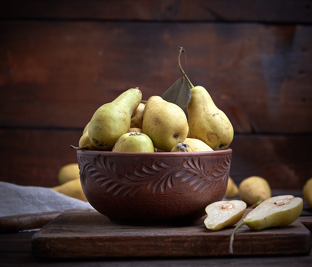 Poires vertes mûres dans un bol d&#39;argile brune