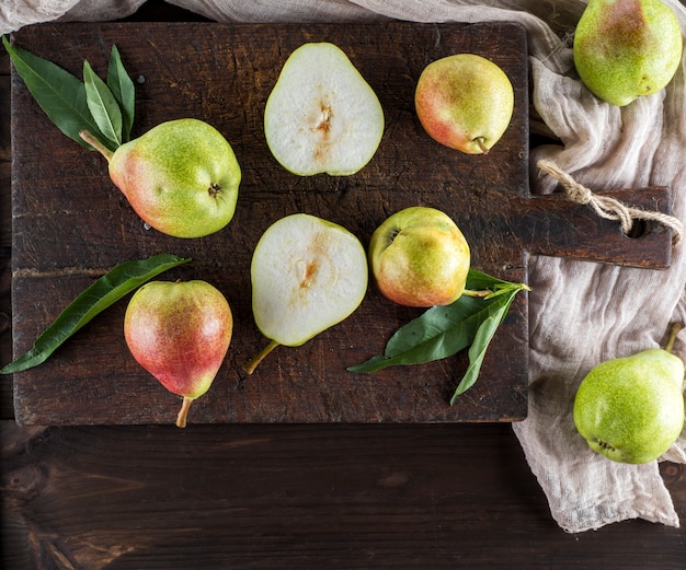 Poires vertes mûres sur une planche de bois brune