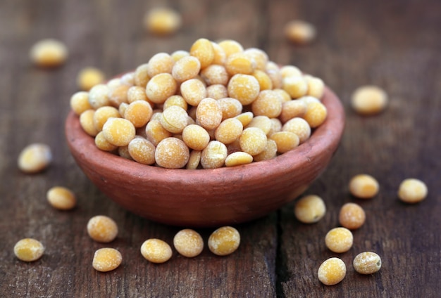 Pois d'Angole sur un pot brun sur une surface en bois