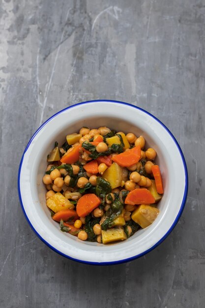 Pois chiches aux carottes et épinards sur bol blanc