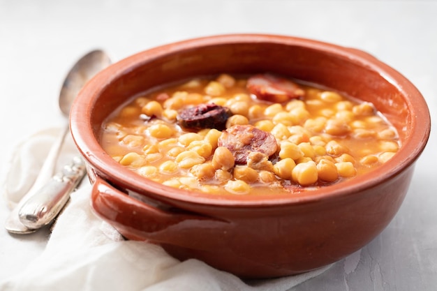 Pois chiches aux saucisses fumées et viande en marmite brune